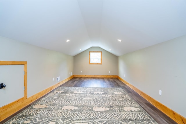 additional living space featuring lofted ceiling and dark hardwood / wood-style flooring