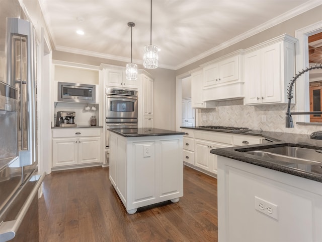 kitchen featuring white cabinetry, stainless steel appliances, a center island, and hanging light fixtures