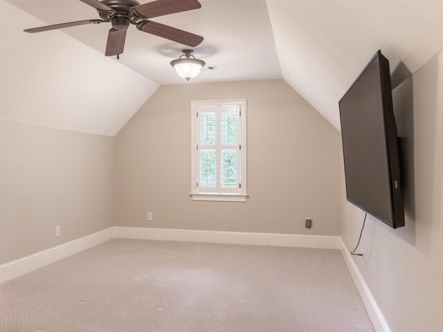 additional living space with lofted ceiling, light colored carpet, and ceiling fan