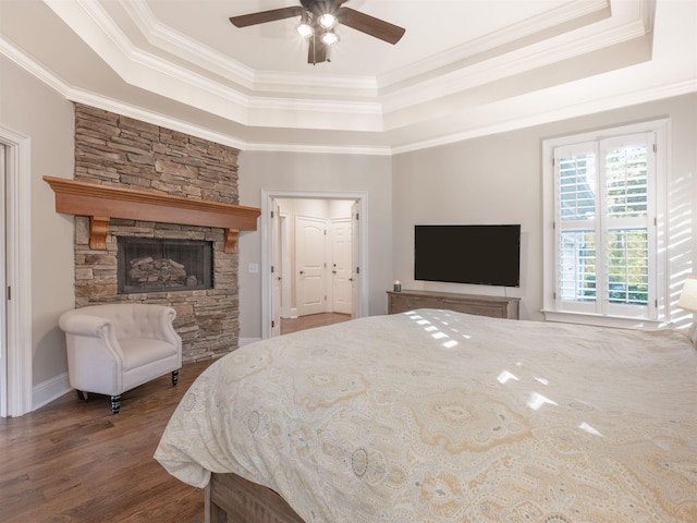 bedroom with a tray ceiling, ornamental molding, and hardwood / wood-style flooring