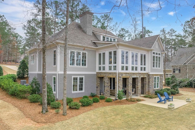 back of house featuring a yard, a sunroom, and a patio area