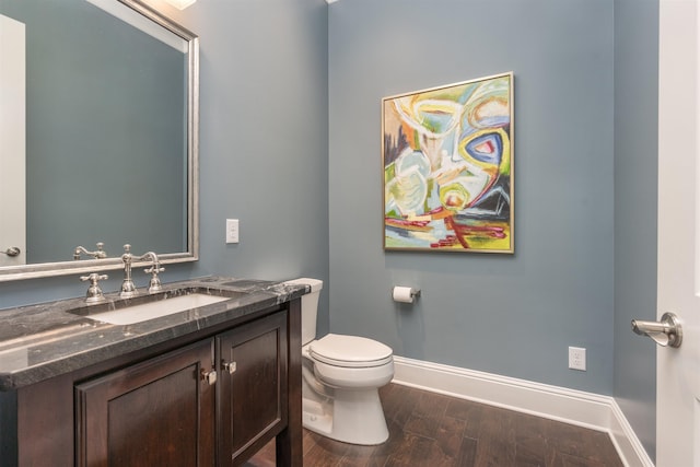 bathroom featuring vanity, hardwood / wood-style floors, and toilet