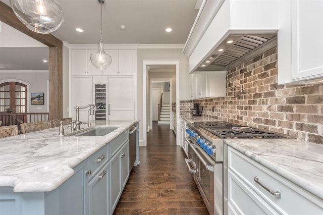 kitchen featuring pendant lighting, sink, crown molding, appliances with stainless steel finishes, and white cabinets