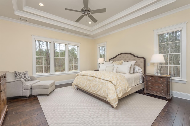 bedroom with ornamental molding, dark hardwood / wood-style flooring, and a raised ceiling