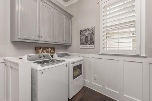 clothes washing area with cabinets, dark hardwood / wood-style floors, and washer and clothes dryer