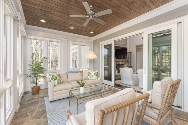 sunroom / solarium with ceiling fan, a healthy amount of sunlight, a fireplace, and wood ceiling