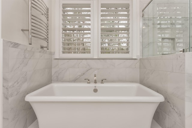 bathroom featuring a bathtub and tile walls