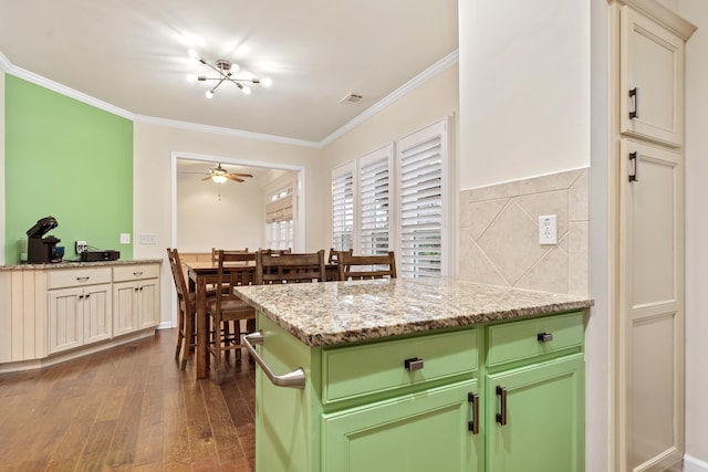 kitchen featuring ornamental molding, dark hardwood / wood-style floors, ceiling fan, and light stone counters