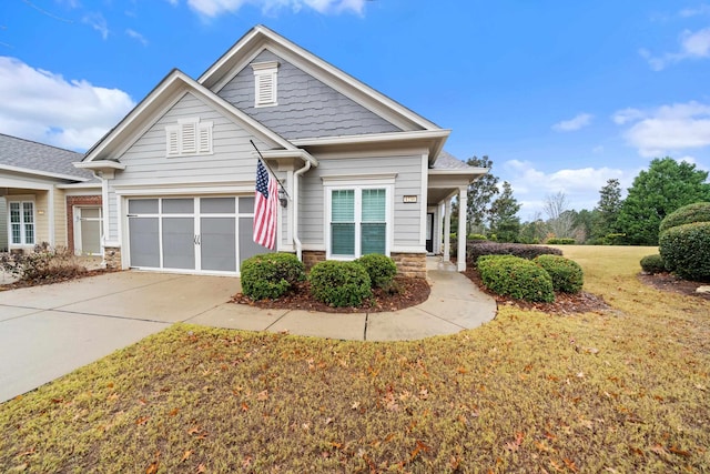 craftsman inspired home with a garage and a front lawn