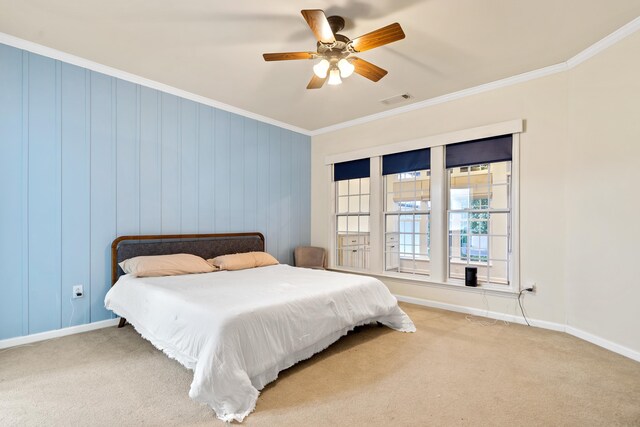 carpeted bedroom with ornamental molding and ceiling fan