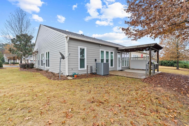 rear view of property featuring cooling unit, a yard, and a patio