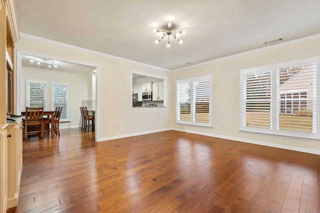 unfurnished room featuring wood-type flooring, ornamental molding, and a notable chandelier