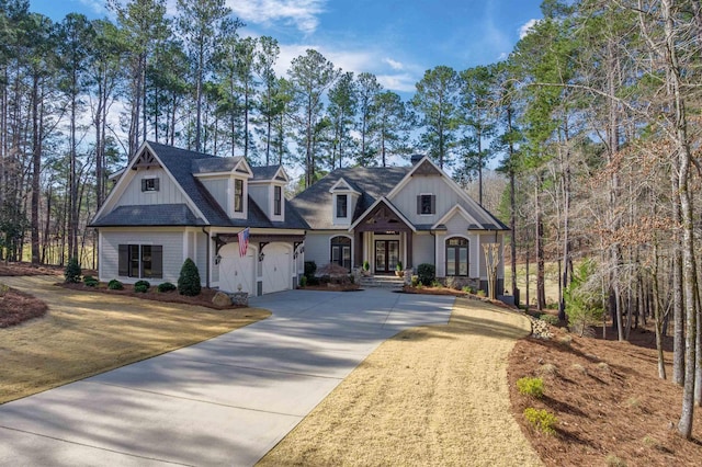 view of front of home with a garage, driveway, and roof with shingles