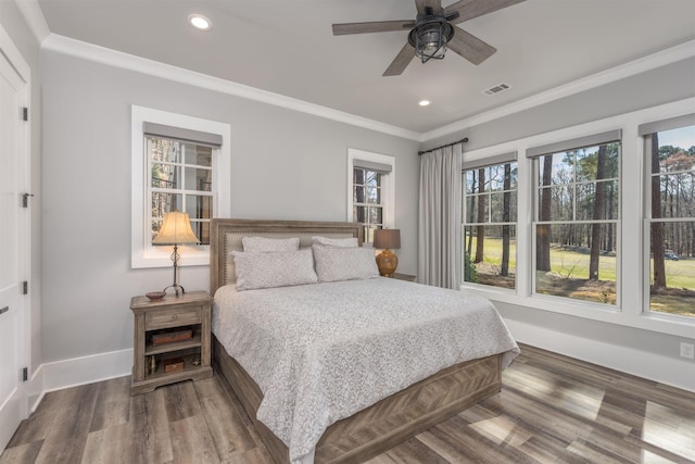 bedroom featuring recessed lighting, wood finished floors, visible vents, baseboards, and ornamental molding