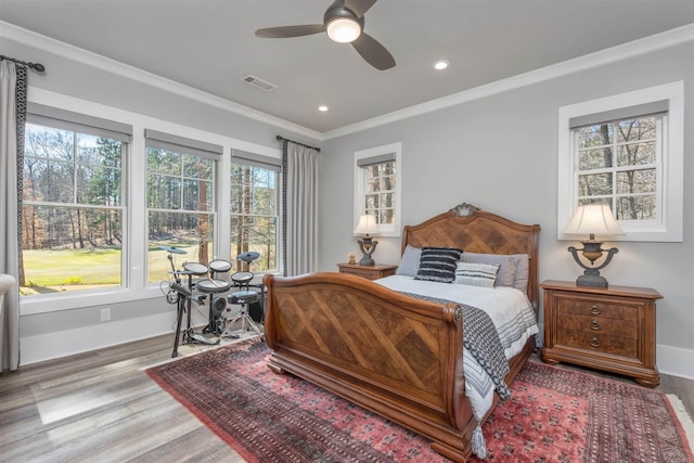 bedroom featuring ornamental molding, visible vents, and wood finished floors