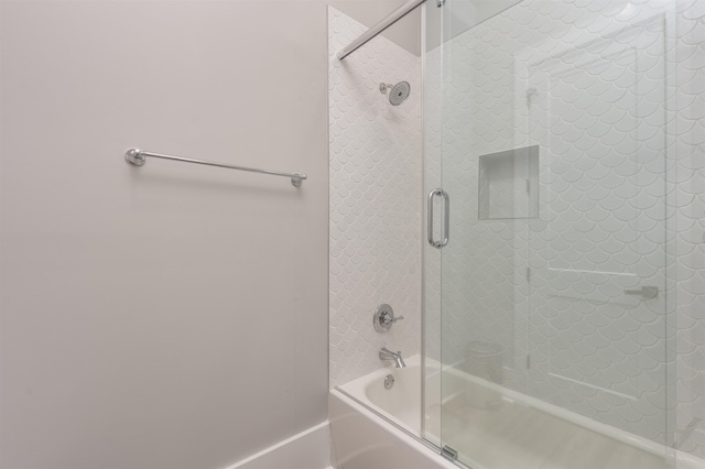 bathroom featuring combined bath / shower with glass door