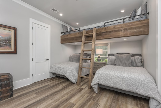 bedroom with crown molding, recessed lighting, visible vents, wood finished floors, and baseboards