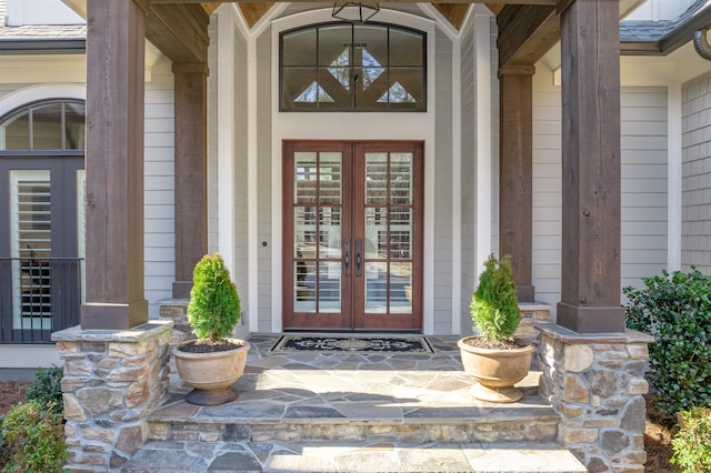 view of exterior entry with french doors and covered porch