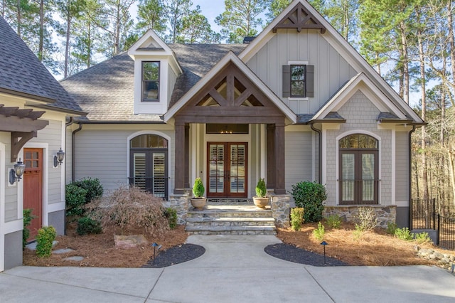 exterior space with french doors, roof with shingles, and board and batten siding