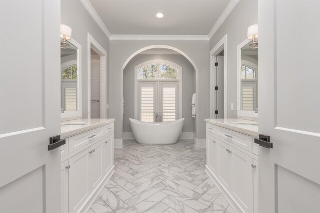 full bath with a sink, marble finish floor, two vanities, and crown molding