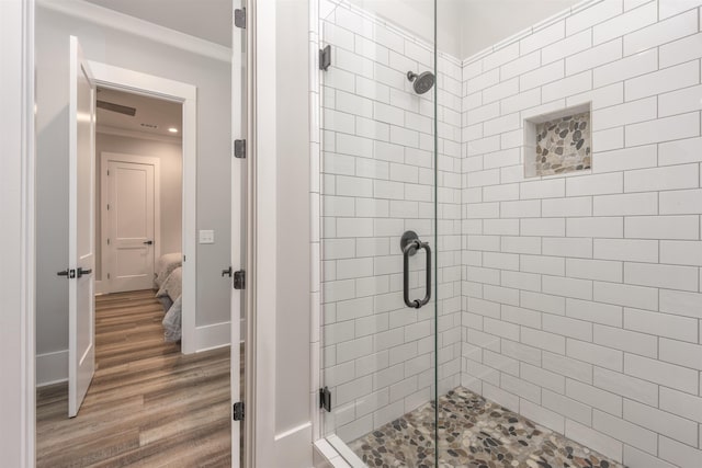 full bath with ensuite bathroom, ornamental molding, a stall shower, wood finished floors, and baseboards