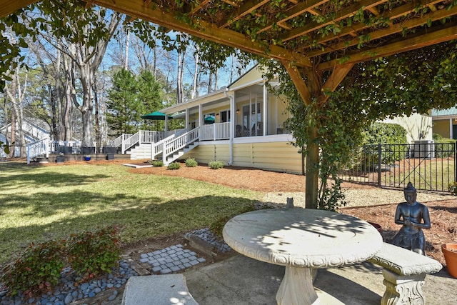 view of yard featuring stairs, fence, and a sunroom