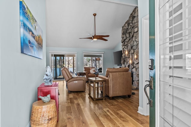 living room featuring wood finished floors, ceiling fan, and vaulted ceiling