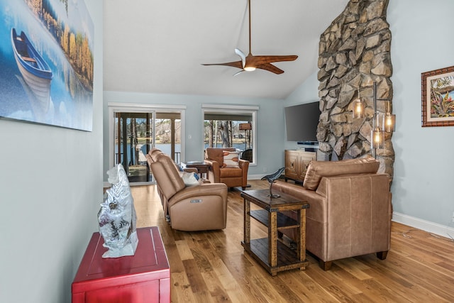 living area featuring baseboards, ceiling fan, and wood finished floors