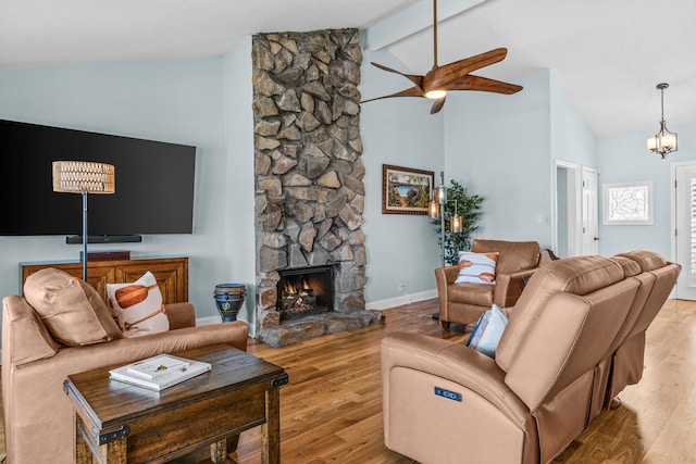 living room featuring beamed ceiling, high vaulted ceiling, a ceiling fan, wood finished floors, and a stone fireplace