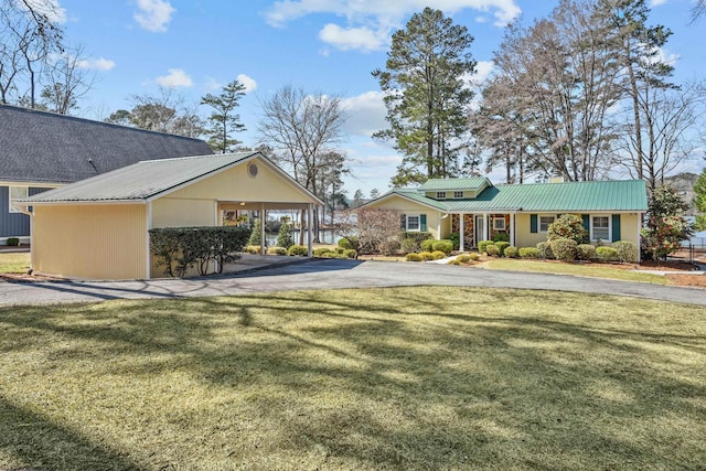 view of yard with aphalt driveway and a carport