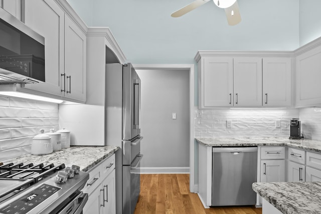 kitchen featuring ceiling fan, white cabinetry, backsplash, and stainless steel appliances