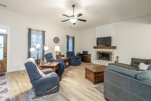 5761 Dixie Hwy, Rutledge, GA 30663 - living area with light wood-style floors, a fireplace with raised hearth, and a ceiling fan