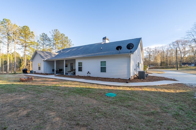 5761 Dixie Hwy, Rutledge, GA 30663 - back of house with central AC unit, a chimney, and a yard