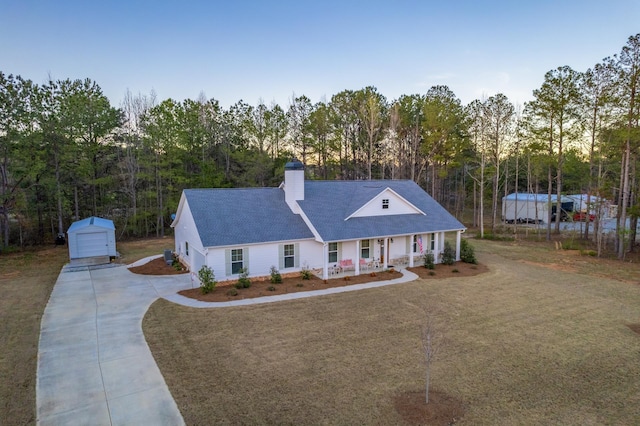 5761 Dixie Hwy, Rutledge, GA 30663 - view of front of property with covered porch, concrete driveway, an outbuilding, a detached garage, and a chimney