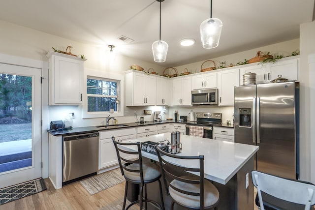 5761 Dixie Hwy, Rutledge, GA 30663 - kitchen with stainless steel appliances, a sink, white cabinetry, and a kitchen breakfast bar