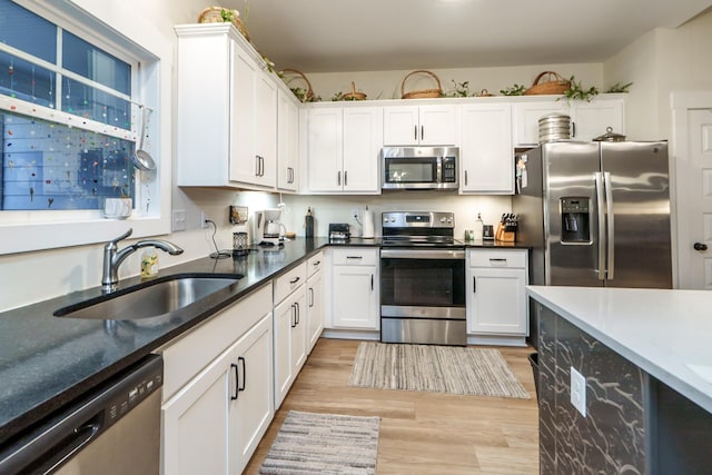 5761 Dixie Hwy, Rutledge, GA 30663 - kitchen featuring stainless steel appliances, a sink, light wood-type flooring, and white cabinets