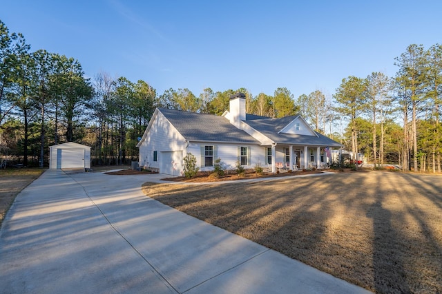 5761 Dixie Hwy, Rutledge, GA 30663 - view of front of home with driveway, a porch, a chimney, a detached garage, and an outbuilding