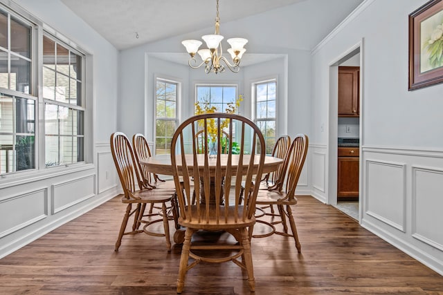 dining room with dark wood-style floors, a notable chandelier, a decorative wall, and vaulted ceiling