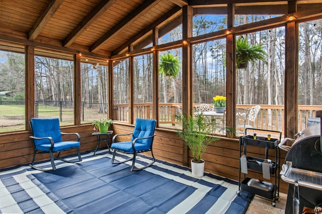 unfurnished sunroom featuring lofted ceiling with beams