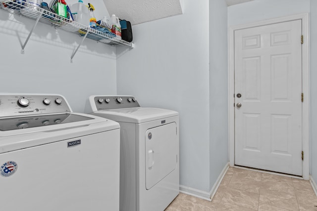 clothes washing area featuring baseboards, independent washer and dryer, and laundry area