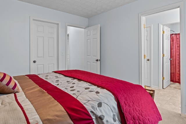 bedroom with light colored carpet and a textured ceiling