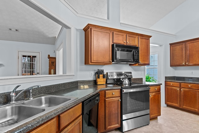 kitchen featuring brown cabinetry, visible vents, black appliances, and a sink