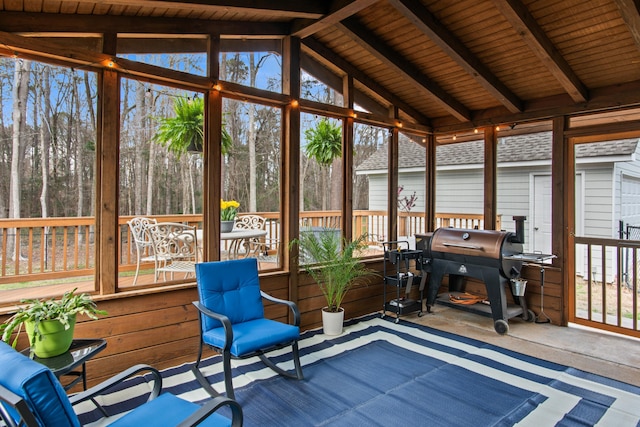 sunroom featuring vaulted ceiling with beams