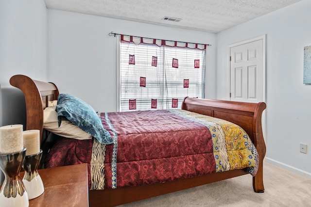 carpeted bedroom with visible vents, baseboards, and a textured ceiling