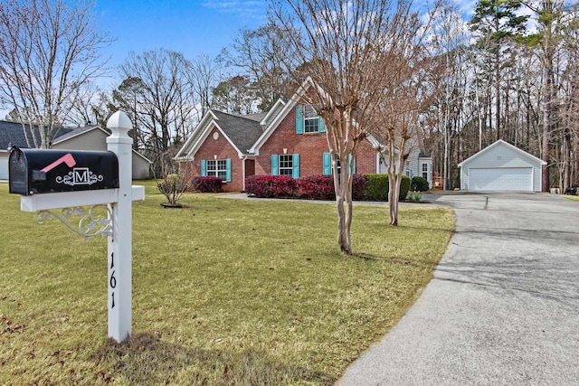 view of front of property with brick siding, an outdoor structure, a detached garage, and a front yard