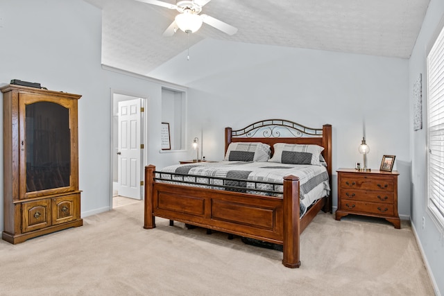 bedroom with a textured ceiling, baseboards, light colored carpet, ceiling fan, and vaulted ceiling