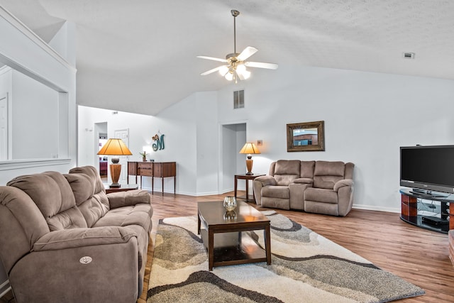 living room with visible vents, baseboards, wood finished floors, high vaulted ceiling, and a ceiling fan