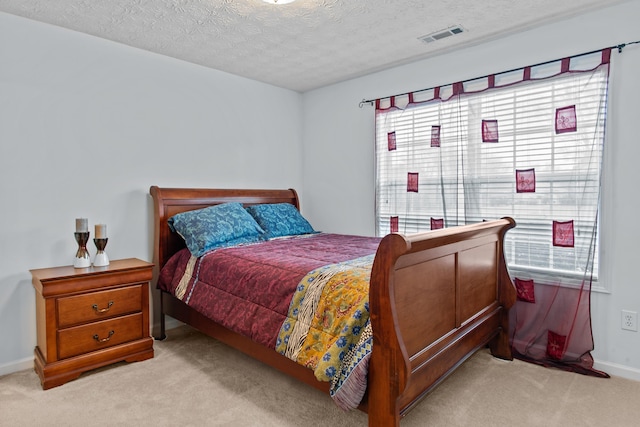 bedroom featuring carpet flooring, baseboards, visible vents, and a textured ceiling