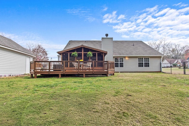 rear view of house with a shingled roof, fence, a chimney, a yard, and a sunroom