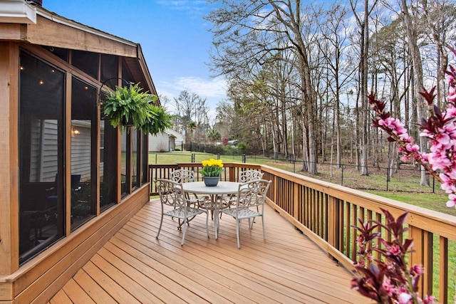 wooden terrace featuring outdoor dining space, a yard, and a fenced backyard